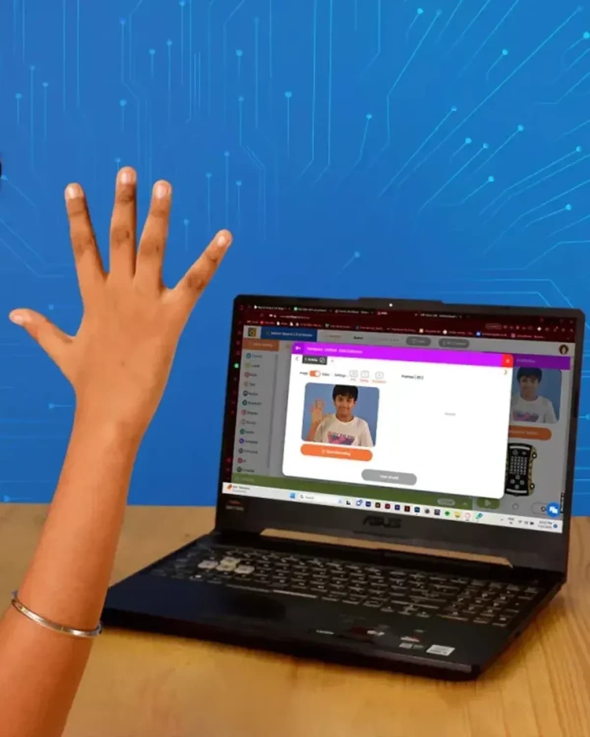 A child raising a hand in front of a laptop camera to control a game they built
