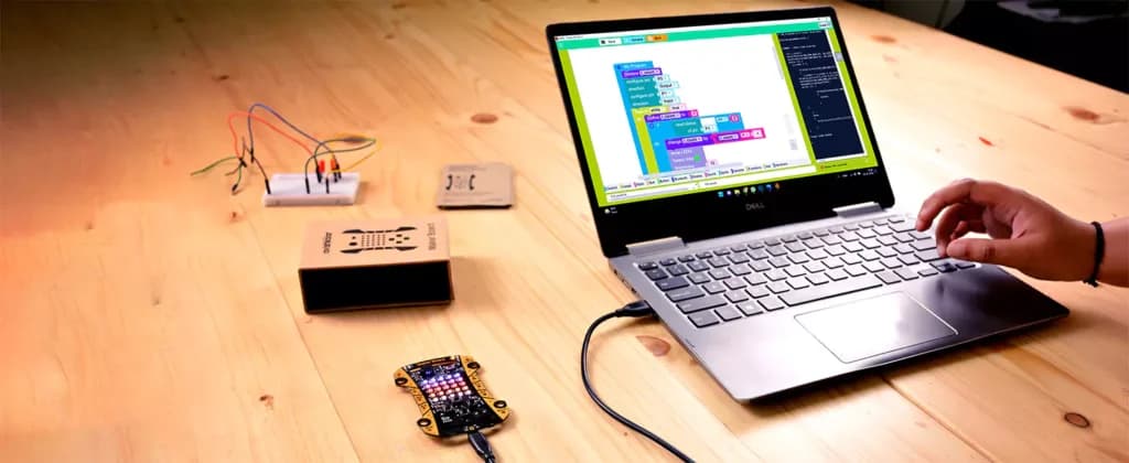 Block code on the laptop, driving the board beside it
